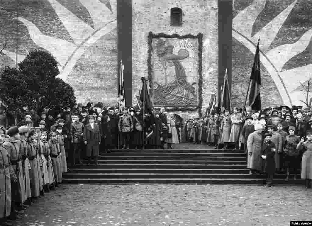 Большевики на открытии барельефа на стене Кремля. После большевистской революции 1917 года на месте нынешнего мавзолея установили барельеф в память о коммунистах, погибших во время революции 1917 года и похороненных в братских могилах у подножия кремлёвских стен. На этой фотографии, снятой в ноябре 1918 года, Владимир Ленин стоит практически на том же месте, где через несколько лет разместят его забальзамированное тело &nbsp;