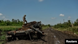 Український військовослужбовець оглядає знищений російський танк у Новодарівці, Запорізька область, 21 липня 2023 року