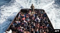 A Libyan coast guardsman stands on a boat during the rescue of 147 illegal immigrants attempting to reach Europe.