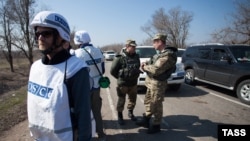 Представители ОБСЕ во время встречи с представителями Совместного центра контроля и координации режима прекращения огня (СЦКК) от России и Украины в поселке Широкино. Донецкая область, 25 марта 2015 года