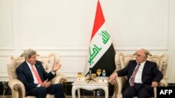 ABŞ-nyň döwlet sekretary Jon Kerri (Ç) Yragyň täze premýer-ministri Haýdar al-Abadi biler gürleşýär. Bagdad, 10-njy sentýabr, 2014.