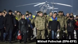Президент України Петро Порошенко (посередині) разом зі звільненими з полону українцями, яких утримували російські гібридні сили на окупованій частині Донбасу. Харків, 27 грудня 2017 року