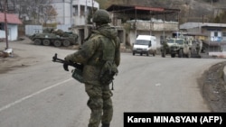A Russian peacekeeper stands guard on a road in the town of Lachin in December 2020.