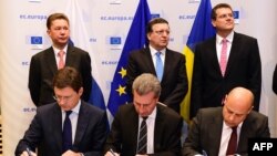Орус жана украин энергетика министрлери А. Новак, Ю.Продан, Еврокомиссиянын өкүлү Г. Оттингер келишимге кол коюшууда.