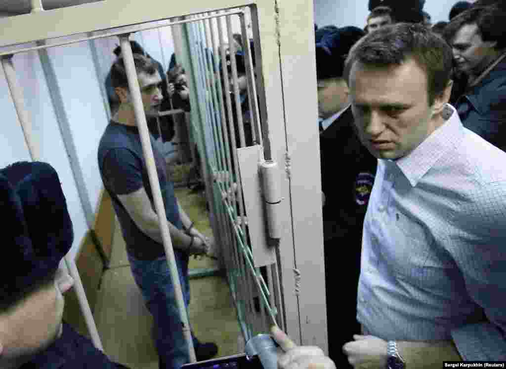 Навальний і його брат Олег (у клітці) на судовому засіданні в Москві в грудні 2014 року. Їм інкримінували крадіжку близько 500 тисяч доларів у кількох російських фірм. Олег та Олексій звинувачення відкидали. Вирок Олексію Навальному не винесли, однак його брат відбув повний строк, 3,5 роки, у в'язниці і був звільнений лише в червні 2018 року