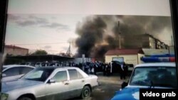 Клубы дыма рядом с отделением полиции в Сатпаеве во время волнений после задержания мужчины, подозреваемого в изнасиловании пятилетней девочки. Карагандинская область, 23–24 июля 2020 года. Кадр любительской видеозаписи.