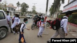 په کراچۍ کې د یوه ښوونځي زده کوونکو تمبوزکونه وهلي او سکول ته روان دي - د ۲۰۲۰ز کال د نومبر میاشتې انځور. 