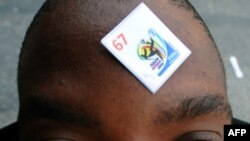 A soccer fan sports his number on his forehead as he waits in line outside a FIFA ticketing office in Johannesburg.