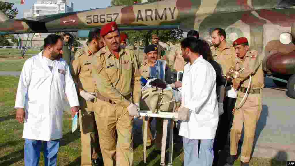 Malala is transported from a helicopter to an army hospital by doctors.