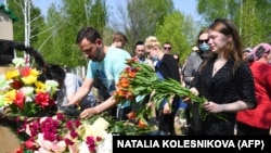 Mourners place flowers at the grave of English teacher Elvira Ignatyeva, who was killed during the shooting in Kazan, at her funeral on May 12. 