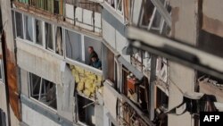Odessada dron hücumundan sonra sakinlər sınmış pəncərələrdən bayıra baxırlar