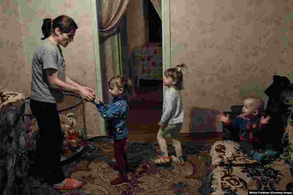 33-річна Тетяна зі своїми трьома дітьми. Вона заразилася ВІЛ від свого чоловіка, який був наркозалежним і помер від ускладнень СНІДу в січні 2016 року. Родина покинула свою домівку під час важких боїв і тепер живе в Краматорську на Донеччині, де їх підтримують неурядові організації та релігійні групи. Вона не може працювати, оскільки єдина, хто доглядає дітей &nbsp;