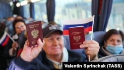 Жителі Донецька показують свої російські паспорти в автобусі, який має доправити їх до виборчої дільниці в Ростовській області Росії для голосування у виборах до російської Держдуми. 17 вересня 2021 року